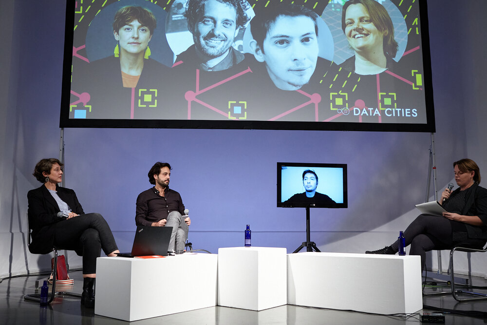 Panel discussion “Citizens for Digital Sovereignty: Shaping Inclusive & Resilient Cities” with Elizabeth Calderón Lüning (left), Rafael Heiber, Alexandre Monnin (screen), and Lieke Ploeger.