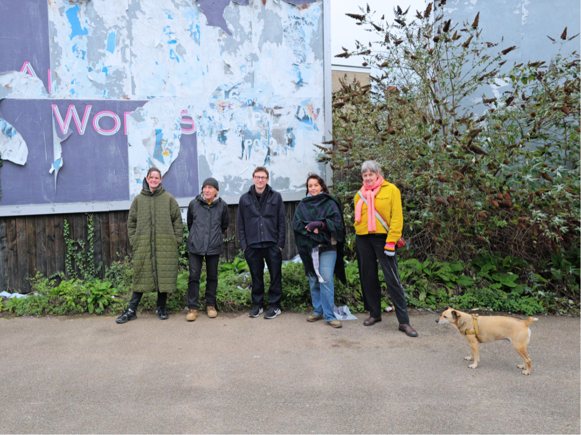 Artists Elly Clarke, Simon Read, Josh Hall, Lora Aziz, Ruth Catlow, with Nick the dog standing in front of 2 unused billboards in Felixstowe.